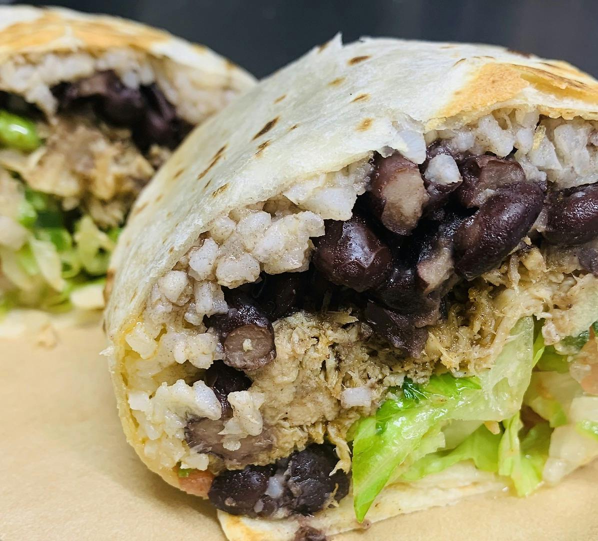a close up of a sandwich with meat and vegetables